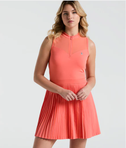 Woman wearing a coral pleated dress on a white background